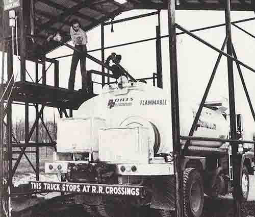 Vintage photo of truck driver filling fuel truck